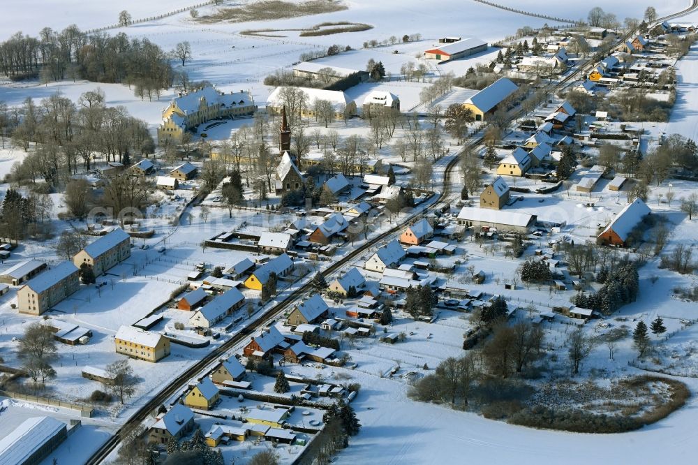 Aerial image Leppin - Wintry snowy agricultural land and field boundaries surround the settlement area of the village in Leppin in the state Mecklenburg - Western Pomerania, Germany