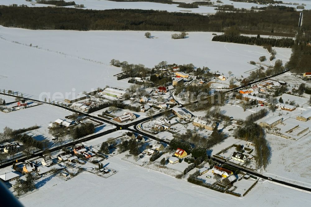 Poggendorf from the bird's eye view: Wintry snowy agricultural land and field boundaries surround the settlement area of the village in Poggendorf in the state Mecklenburg - Western Pomerania, Germany