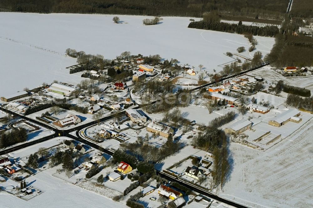 Aerial image Poggendorf - Wintry snowy agricultural land and field boundaries surround the settlement area of the village in Poggendorf in the state Mecklenburg - Western Pomerania, Germany