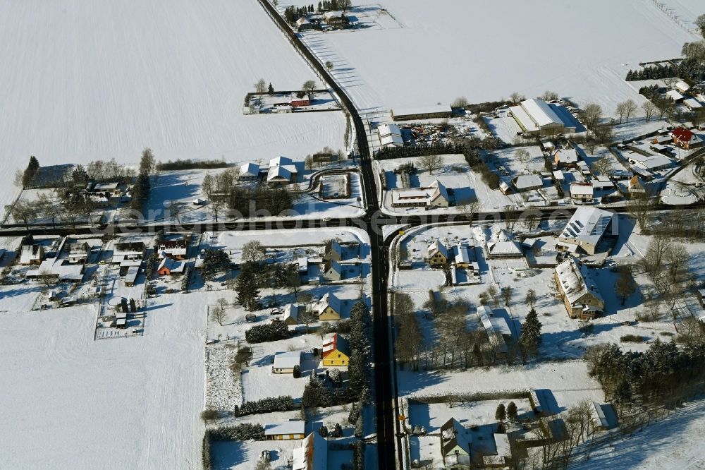 Aerial photograph Poggendorf - Wintry snowy agricultural land and field boundaries surround the settlement area of the village in Poggendorf in the state Mecklenburg - Western Pomerania, Germany