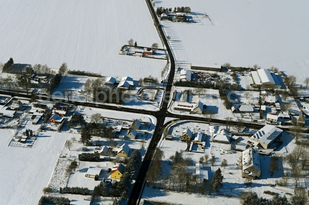 Poggendorf from above - Wintry snowy agricultural land and field boundaries surround the settlement area of the village in Poggendorf in the state Mecklenburg - Western Pomerania, Germany