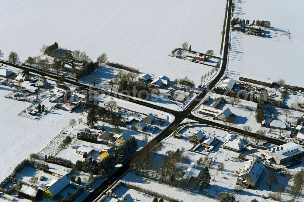 Poggendorf from the bird's eye view: Wintry snowy agricultural land and field boundaries surround the settlement area of the village in Poggendorf in the state Mecklenburg - Western Pomerania, Germany