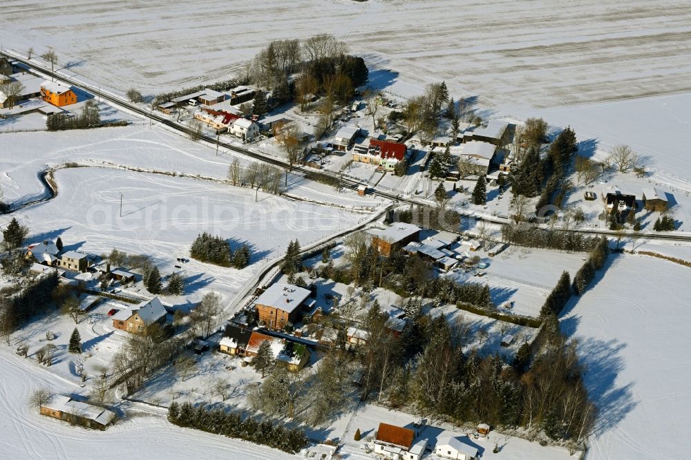 Prützmannshagen from above - Wintry snowy agricultural land and field boundaries surround the settlement area of the village in Pruetzmannshagen in the state Mecklenburg - Western Pomerania, Germany