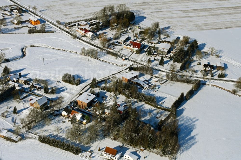 Prützmannshagen from the bird's eye view: Wintry snowy agricultural land and field boundaries surround the settlement area of the village in Pruetzmannshagen in the state Mecklenburg - Western Pomerania, Germany