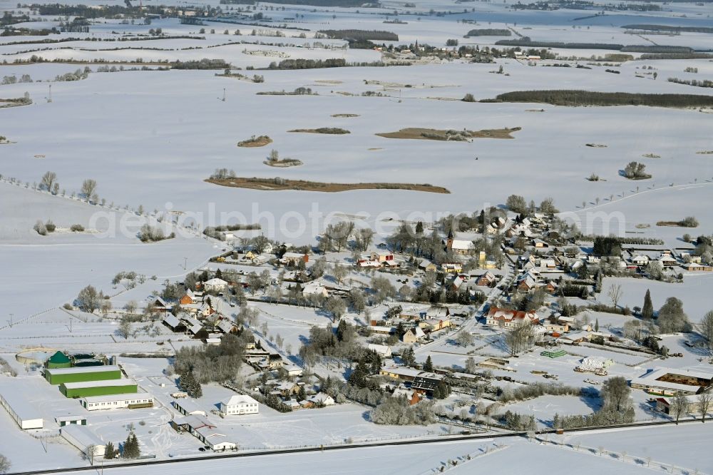 Rehberg from above - Wintry snowy agricultural land and field boundaries surround the settlement area of the village in Rehberg in the state Mecklenburg - Western Pomerania, Germany