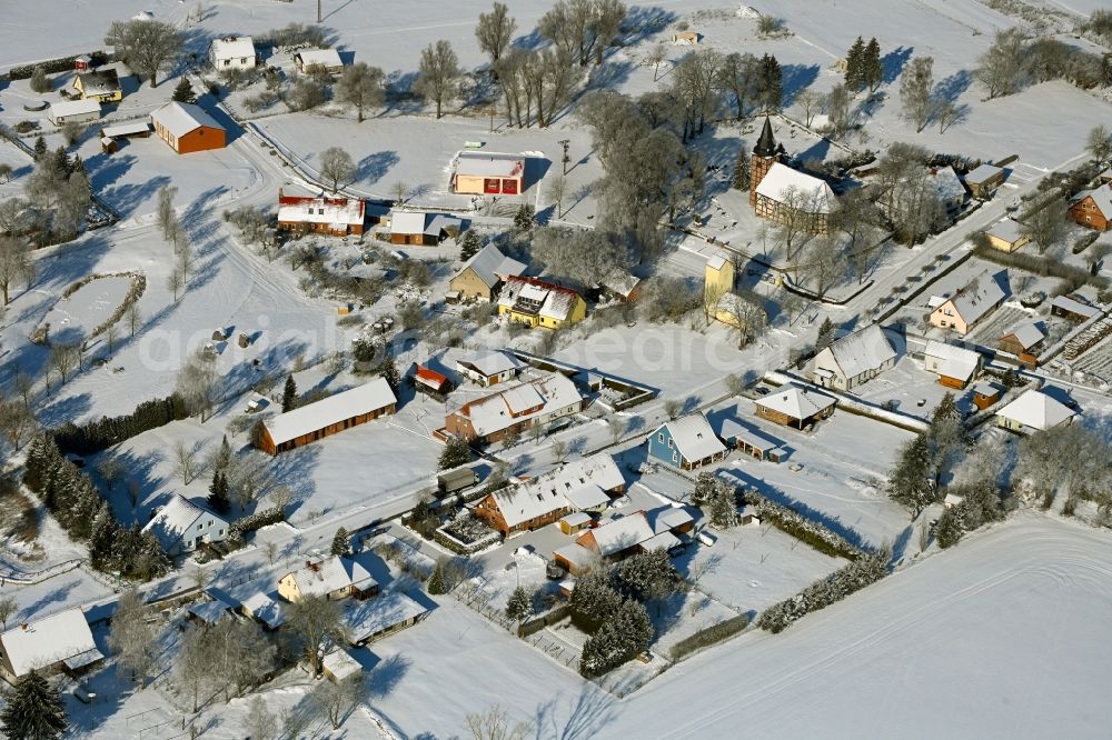 Aerial image Rehberg - Wintry snowy agricultural land and field boundaries surround the settlement area of the village in Rehberg in the state Mecklenburg - Western Pomerania, Germany