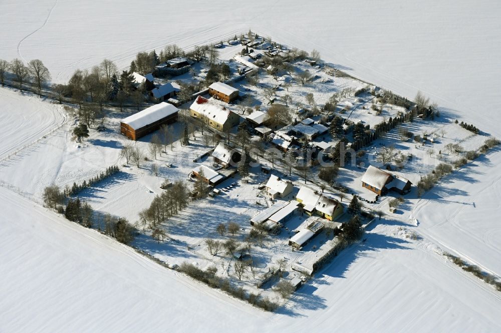 Rosemarsow from above - Wintry snowy agricultural land and field boundaries surround the settlement area of the village in Rosemarsow in the state Mecklenburg - Western Pomerania, Germany