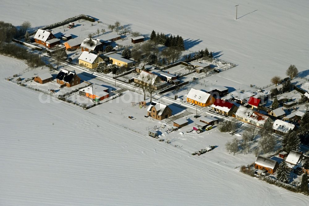 Aerial image Rosemarsow - Wintry snowy agricultural land and field boundaries surround the settlement area of the village in Rosemarsow in the state Mecklenburg - Western Pomerania, Germany