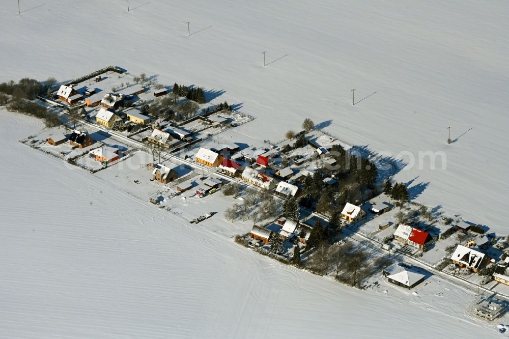 Aerial photograph Rosemarsow - Wintry snowy agricultural land and field boundaries surround the settlement area of the village in Rosemarsow in the state Mecklenburg - Western Pomerania, Germany