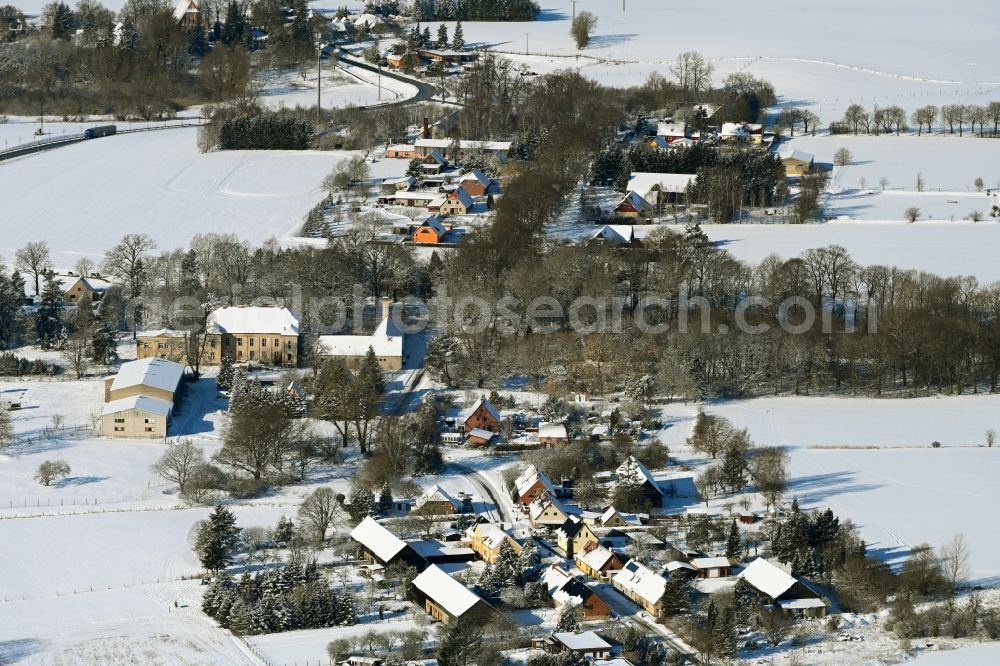 Tentzerow from above - Wintry snowy agricultural land and field boundaries surround the settlement area of the village in Tentzerow in the state Mecklenburg - Western Pomerania, Germany