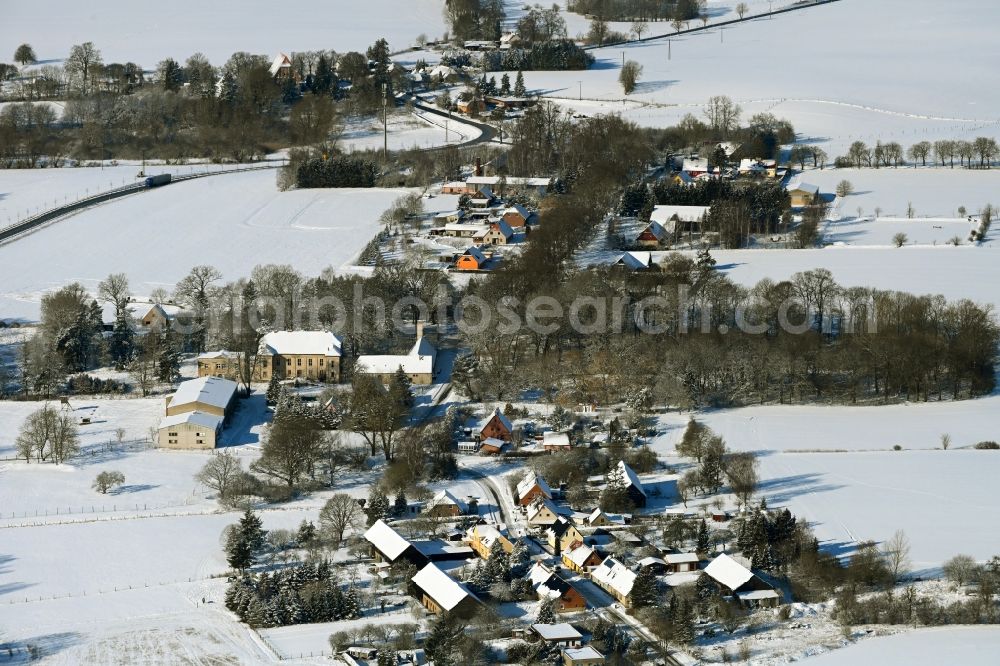 Tentzerow from the bird's eye view: Wintry snowy agricultural land and field boundaries surround the settlement area of the village in Tentzerow in the state Mecklenburg - Western Pomerania, Germany