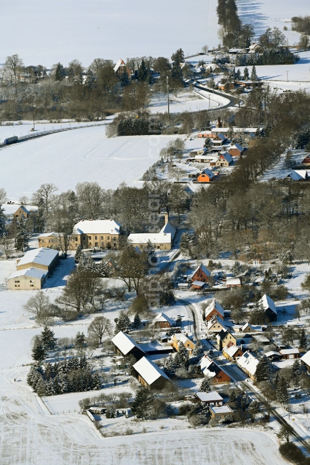 Aerial image Tentzerow - Wintry snowy agricultural land and field boundaries surround the settlement area of the village in Tentzerow in the state Mecklenburg - Western Pomerania, Germany