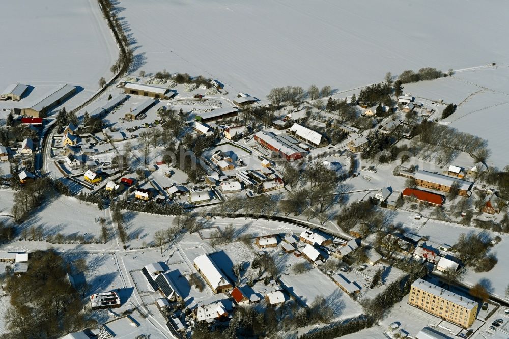 Vorbein from the bird's eye view: Wintry snowy agricultural land and field boundaries surround the settlement area of the village in Vorbein in the state Mecklenburg - Western Pomerania, Germany