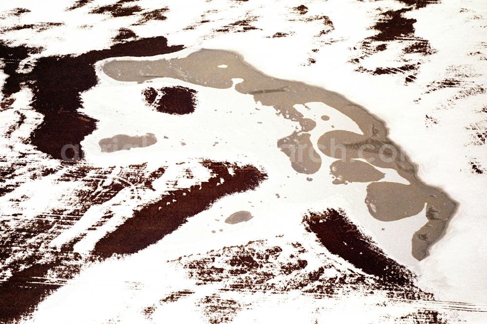 Aerial photograph Neulewin - Wintry snowy Agricultural fields embossed of soil erosion and ice and snow and water structures looks like a face in Neulewin in the state Brandenburg, Germany