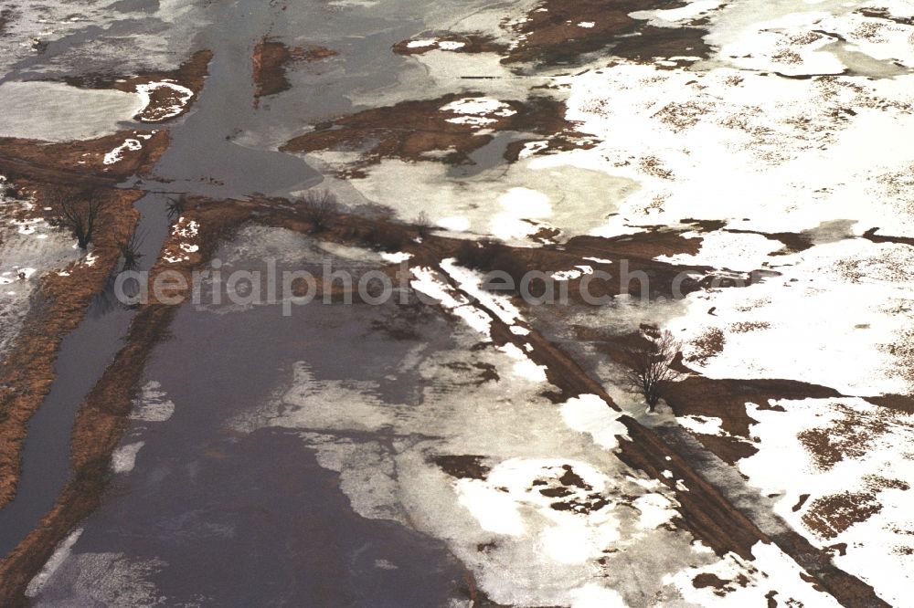 Neulewin from above - Wintry snowy Agricultural fields embossed of soil erosion and ice and snow and water structures in Neulewin in the state Brandenburg, Germany