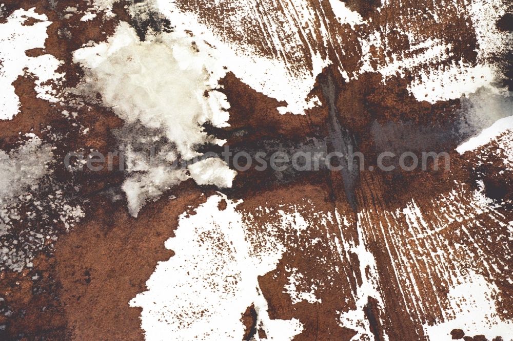 Aerial photograph Neulewin - Wintry snowy Agricultural fields embossed of soil erosion and ice and snow and water structures in Neulewin in the state Brandenburg, Germany