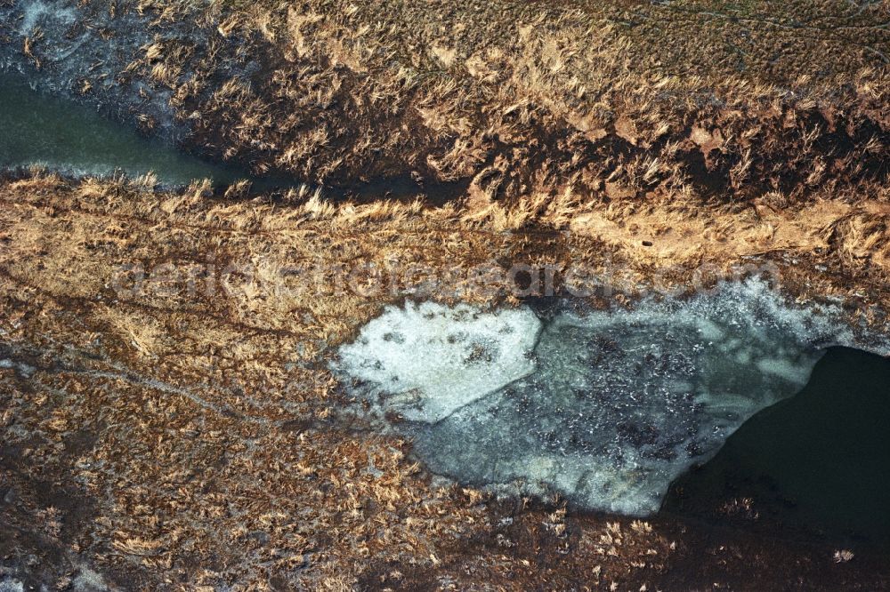 Neulewin from above - Wintry snowy Agricultural fields embossed of soil erosion and ice and snow and water structures in Neulewin in the state Brandenburg, Germany