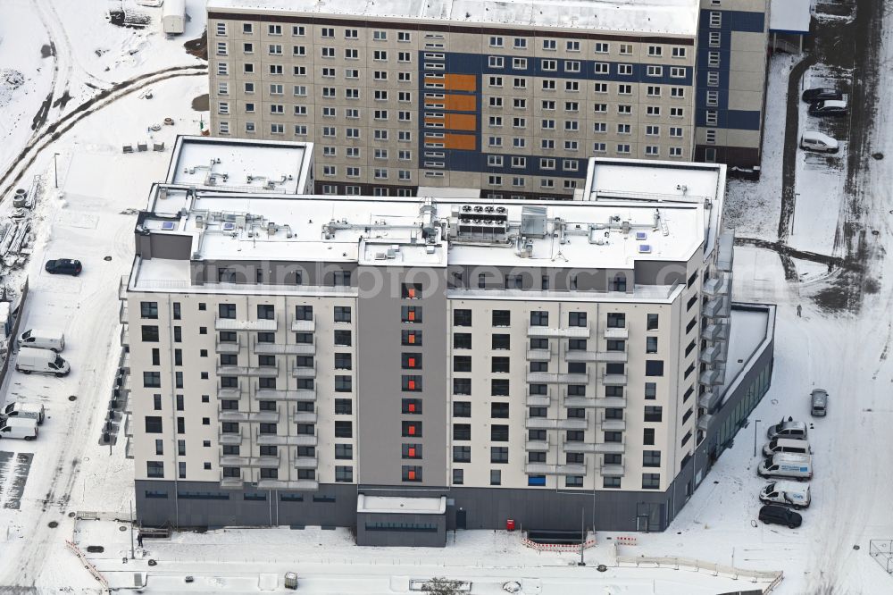 Berlin from the bird's eye view: Wintry snowy construction site for the new residential and commercial Corner house - building on Marzahner Chaussee Ecke Allee of Kosmonauten in the district Marzahn in Berlin, Germany