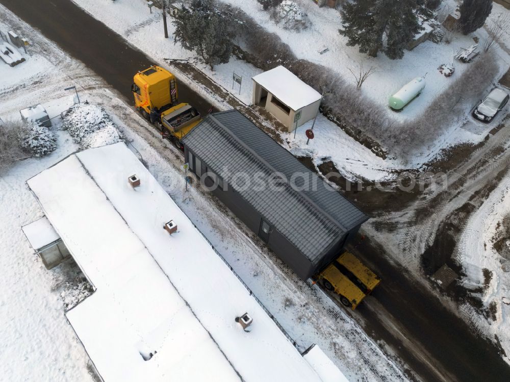 Aerial photograph Groß Daberkow - Wintry snowy single-family house - delivery as a chalet - tiny house with a heavy load transport on the road to the pastor's house in Gross Daberkow in the state Mecklenburg-Western Pomerania, Germany