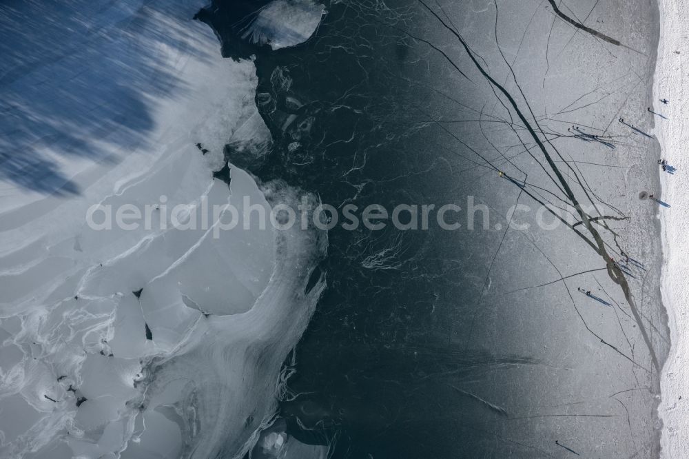 Aerial photograph Dankern - Wintry snowy strollers and passers-by walk on the ice sheet of the frozen bank areas of the lake - surface of Dankernsee in Dankern in the state Lower Saxony, Germany