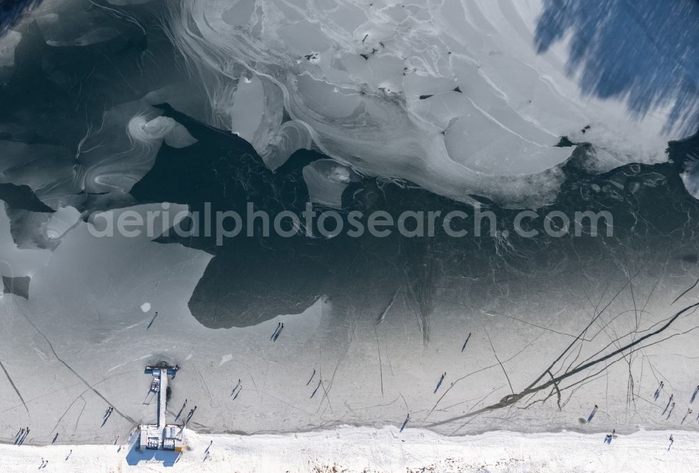 Dankern from above - Wintry snowy strollers and passers-by walk on the ice sheet of the frozen bank areas of the lake - surface of Dankernsee in Dankern in the state Lower Saxony, Germany