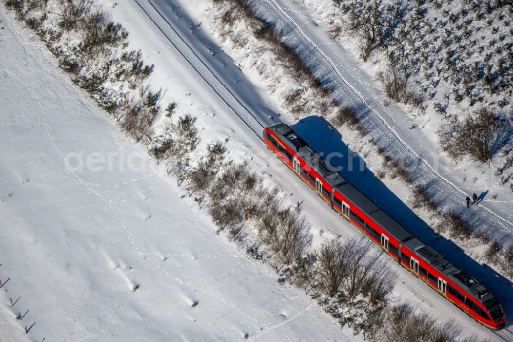 Silbach from the bird's eye view: Wintry snowy driving a Regional Express - train on the track route in Silbach in the state North Rhine-Westphalia, Germany