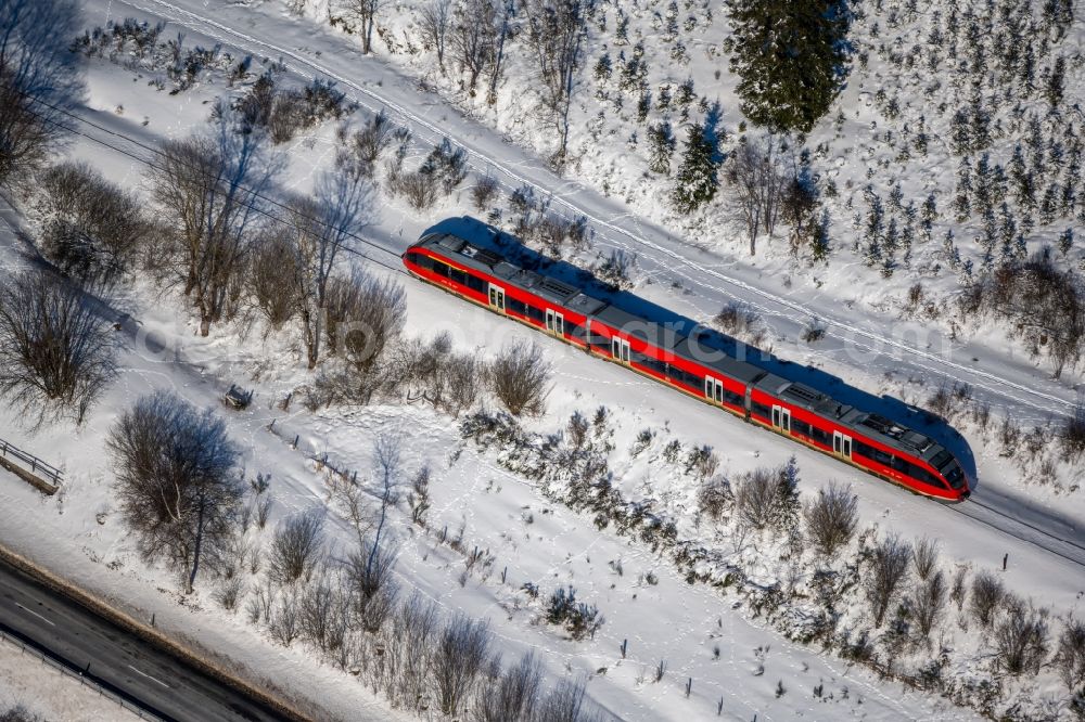 Aerial image Silbach - Wintry snowy driving a Regional Express - train on the track route in Silbach in the state North Rhine-Westphalia, Germany