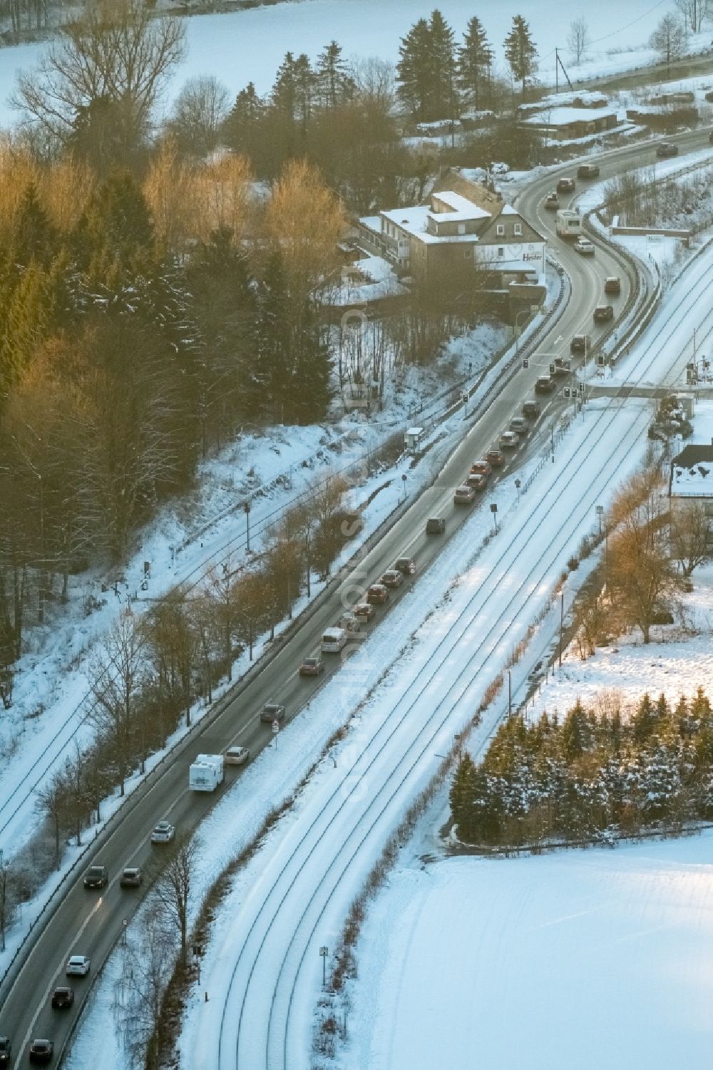 Olsberg from the bird's eye view: Wintry snowy landscape with Motor vehicles in traffic along the Bundestrasse B7 in the district Bigge in Olsberg in the state North Rhine-Westphalia