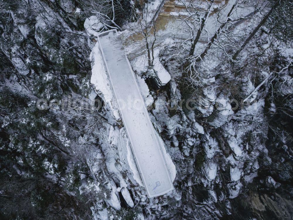 Lohmen from above - Wintry snowy rock massif and mountain landscape with the Bastei viewpoint - platform on the Basteiweg road in Lohmen, Elbe Sandstone Mountains in the state of Saxony, Germany