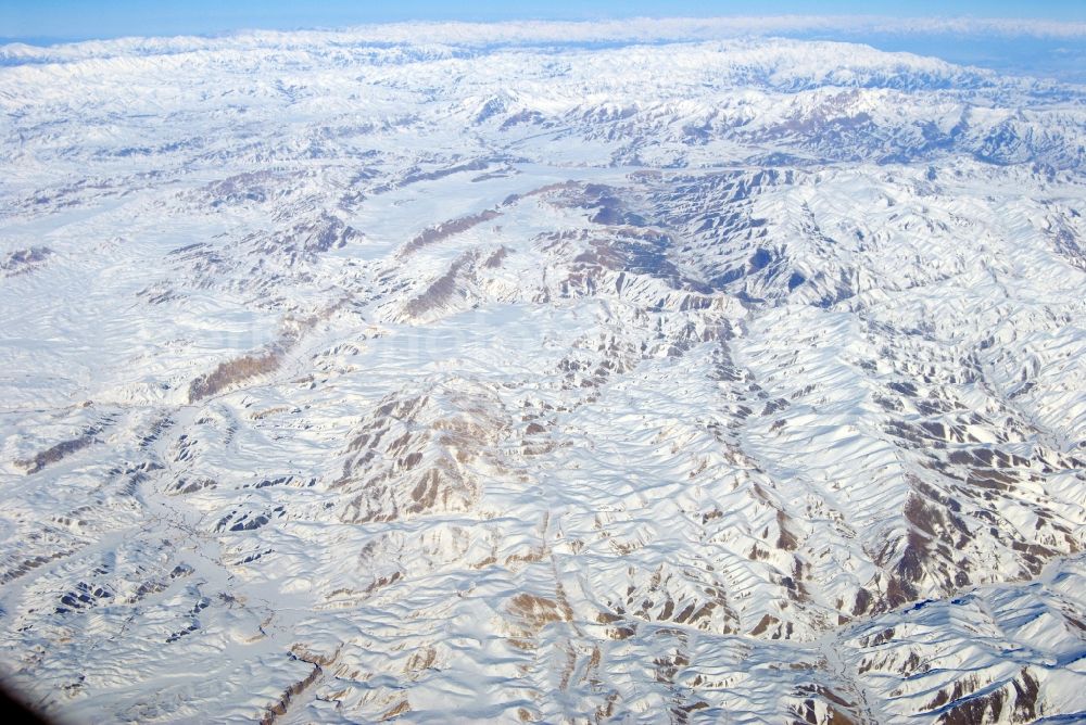 Aerial image Kandahar - Wintry snowy rock and mountain landscape Hindu Kush in Kandahar in Afghanistan