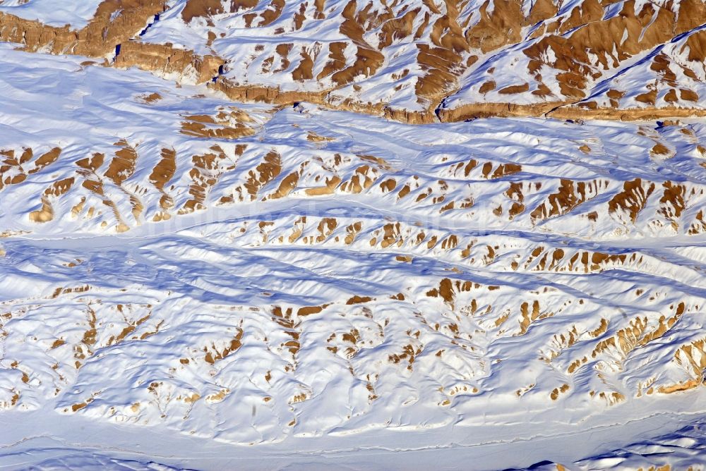 Aerial image Kandahar - Wintry snowy rock and mountain landscape Hindu Kush in Kandahar in Afghanistan