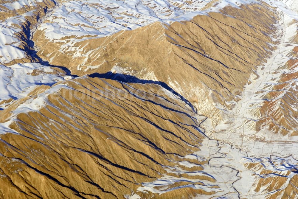 Aerial image Kandahar - Wintry snowy rock and mountain landscape Hindu Kush in Kandahar in Afghanistan