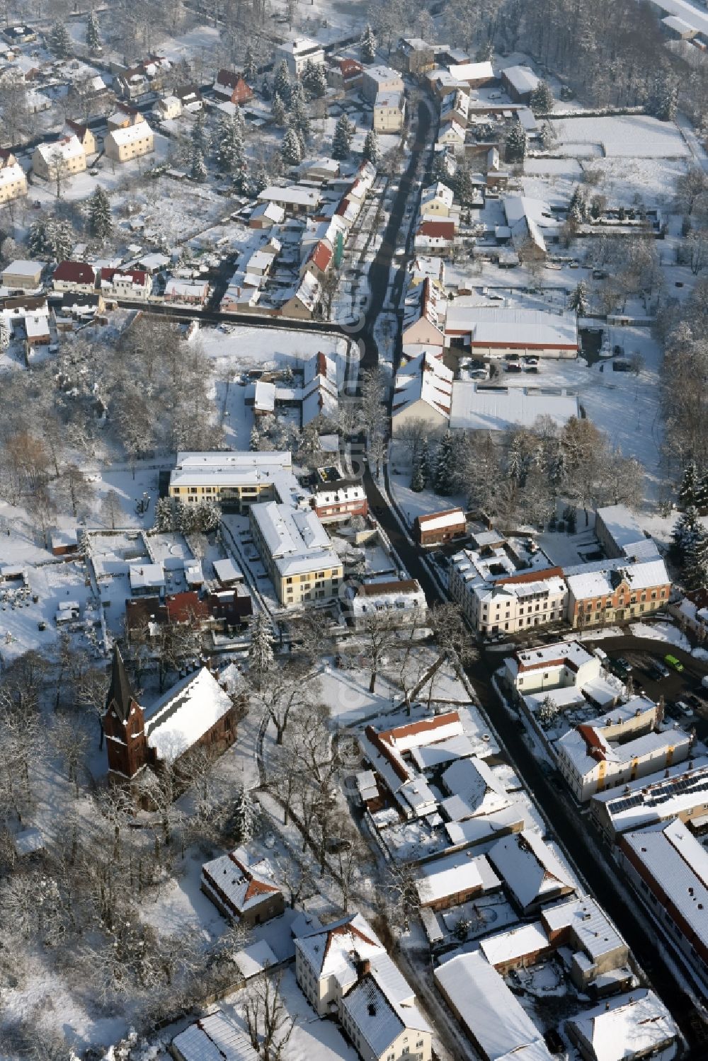 Werneuchen from the bird's eye view: Wintry snowy town Hall building of the City Council at the market downtown in Werneuchen in the state Brandenburg