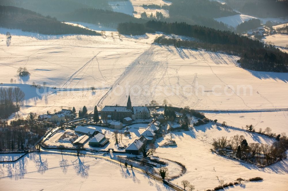 Aerial image Arnsberg - Wintry snowy Complex of buildings of the monastery Oelinghausen in the district Holzen in Arnsberg in the state North Rhine-Westphalia