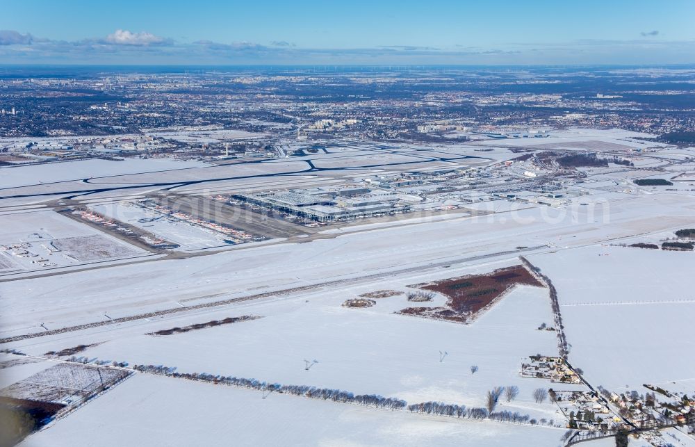 Aerial photograph Schönefeld - Wintry snowy runway with hangar taxiways and terminals on the grounds of the airport BER International in Schoenefeld in the state Brandenburg, Germany