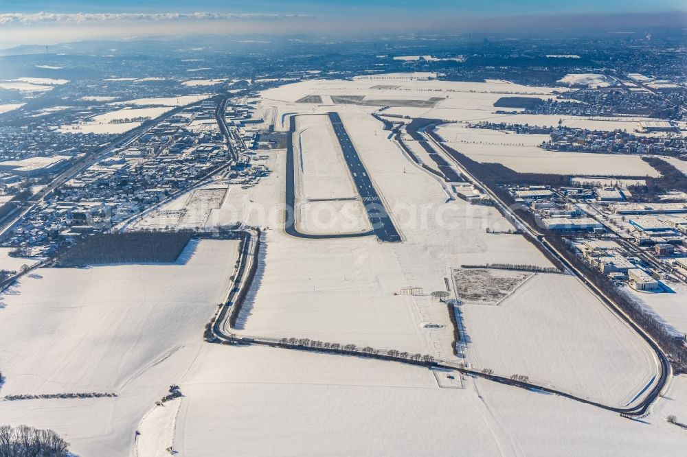 Dortmund from above - Wintry snowy runway with hangar taxiways and terminals on the grounds of the airport in Dortmund in the state North Rhine-Westphalia, Germany