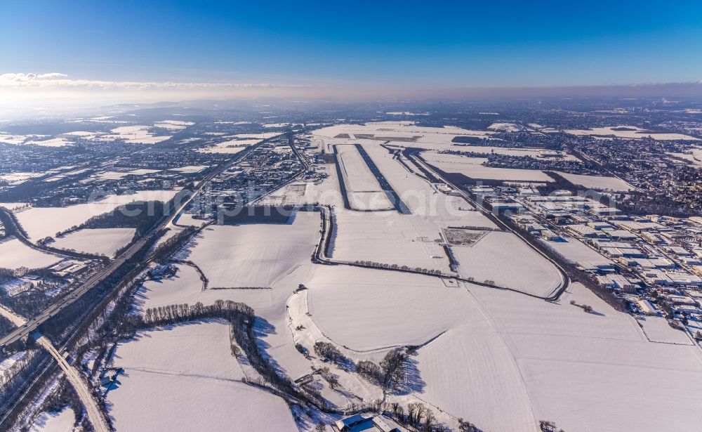 Dortmund from above - Wintry snowy runway with hangar taxiways and terminals on the grounds of the airport in Dortmund in the state North Rhine-Westphalia, Germany