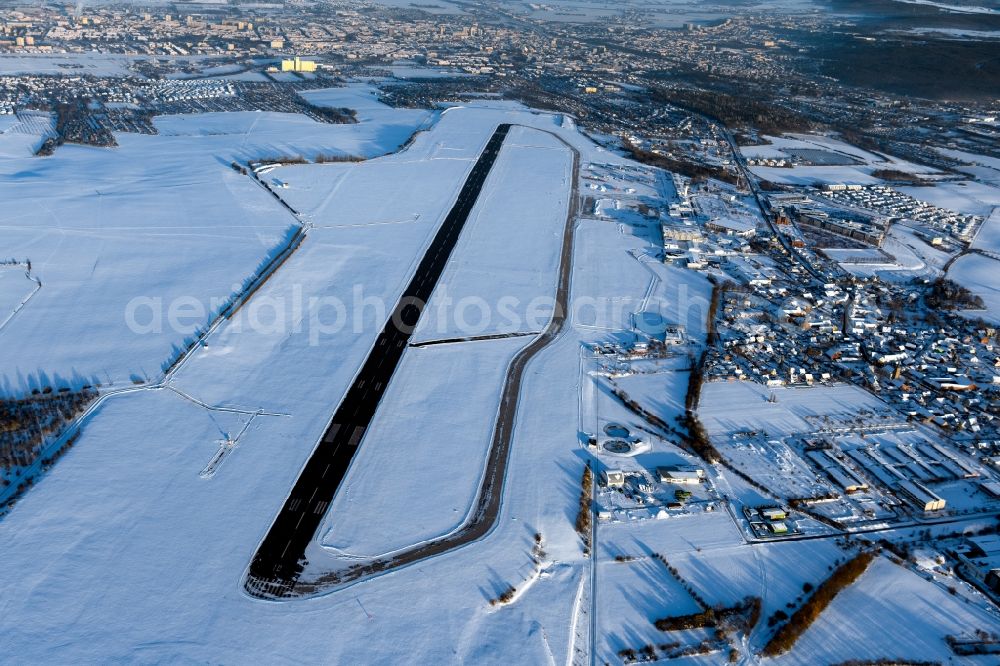 Erfurt from the bird's eye view: Wintry snowy runway with hangar taxiways and terminals on the grounds of the airport in the district Bindersleben in Erfurt in the state Thuringia, Germany