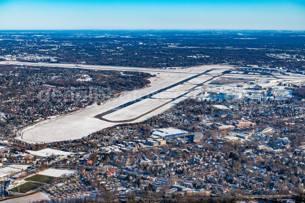 Hamburg from the bird's eye view: Wintry snowy runway with hangar taxiways and terminals on the grounds of the airport in the district Fuhlsbuettel in Hamburg, Germany