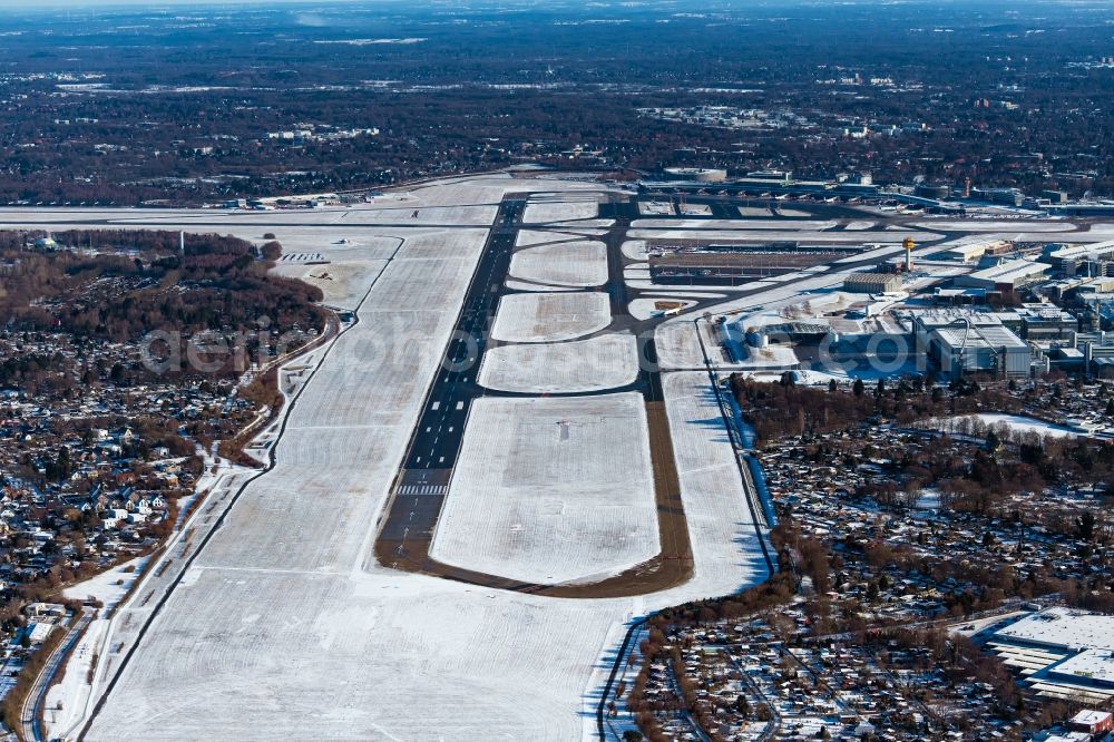 Aerial image Hamburg - Wintry snowy runway with hangar taxiways and terminals on the grounds of the airport in the district Fuhlsbuettel in Hamburg, Germany