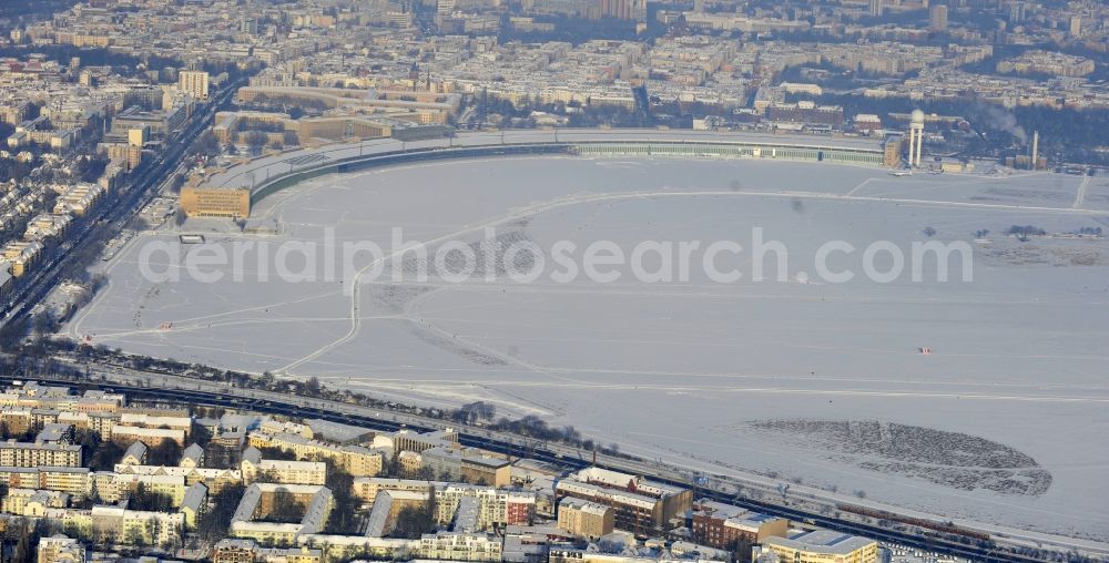 Berlin from above - Wintry snowy runway with hangar taxiways and terminals on the grounds of the airport in the district Tempelhof in Berlin, Germany