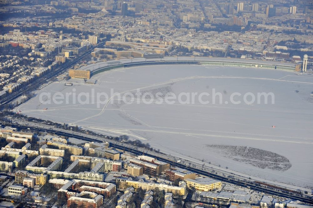 Berlin from the bird's eye view: Wintry snowy runway with hangar taxiways and terminals on the grounds of the airport in the district Tempelhof in Berlin, Germany