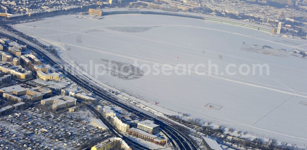 Berlin from above - Wintry snowy runway with hangar taxiways and terminals on the grounds of the airport in the district Tempelhof in Berlin, Germany