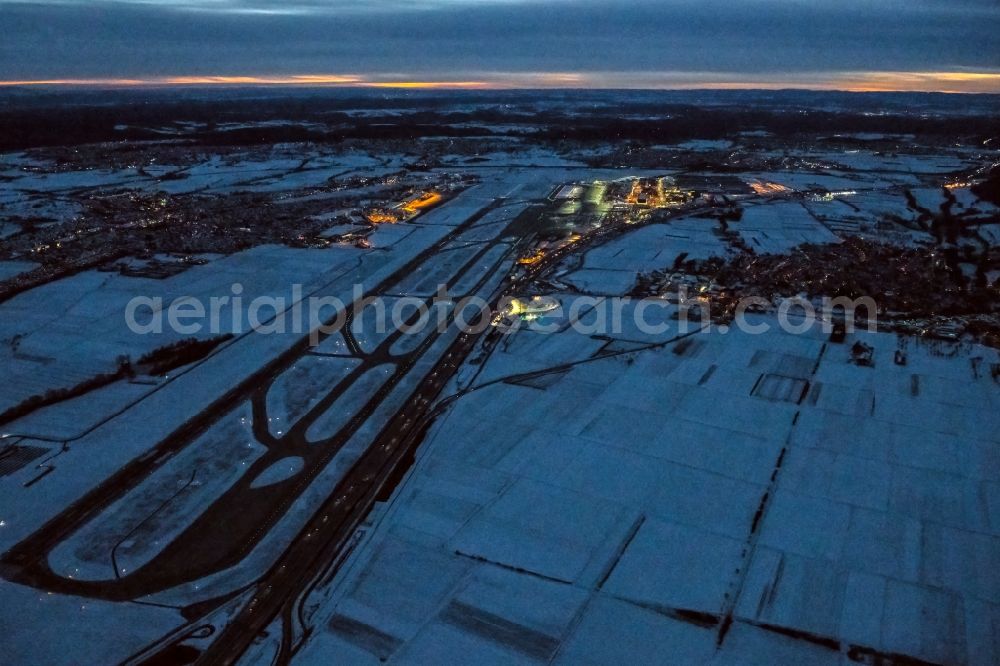 Stuttgart from above - Wintry snowy runway with hangar taxiways and terminals on the grounds of the airport in Stuttgart in the state Baden-Wuerttemberg, Germany