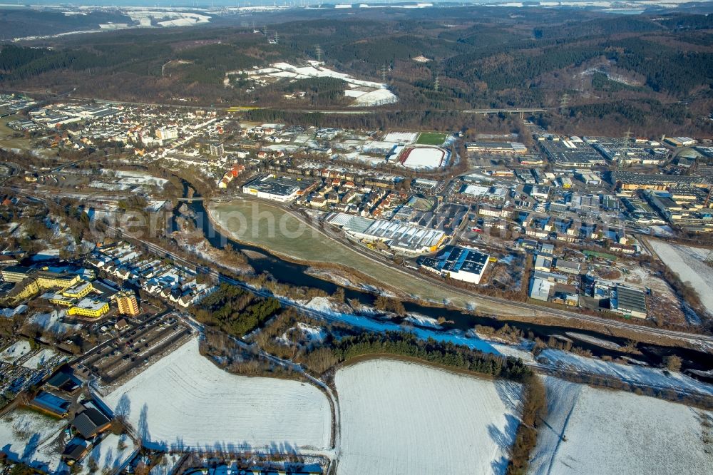 Arnsberg from the bird's eye view: Wintry snowy Industrial estate and company settlement Arnsberger Strasse on the banks of the river Ruhr in the district Huesten in Arnsberg in the state North Rhine-Westphalia