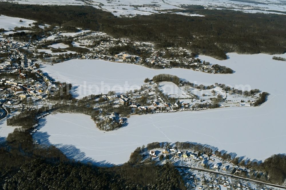 Aerial image Feldberg - Wintry snowy peninsula with land access and shore area on the Feldberger Haussee in Feldberg in the state Mecklenburg - Western Pomerania, Germany