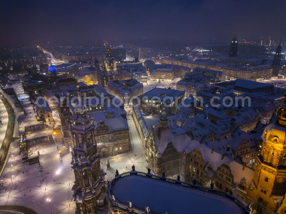 Dresden from the bird's eye view: A wintery, snow-covered view of the Cathedral of the Holy Trinity in Dresden in the state of Saxony. It is the cathedral of the Dresden-Meissen diocese and a parish church of Dresden. As a former Catholic court church, which was built in the Baroque style between 1739 and 1755, it is connected to the residential palace by a walkway and is located on the banks of the Elbe in the old town