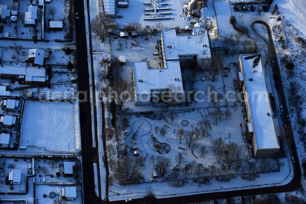 Aerial photograph Berlin - Wintry snowy park with playground with sandy areas on the Kindergaerten NordOst Zu den Seen on Elsenstrasse in Berlin