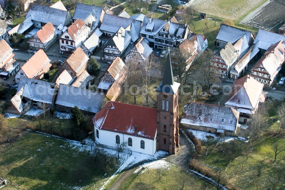 Hunspach from the bird's eye view: Wintry snowy protestantic Church building in the village of in Hunspach in Grand Est, France