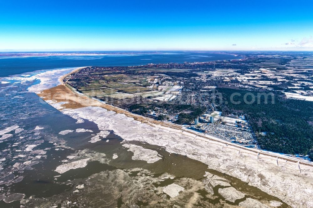 Cuxhaven from the bird's eye view: Wintry snowy coastline on the sandy beach of the North Sea and the nearby districts of Cuxhaven Duhnen , Sahlenburg and Doese with residential areas and surrounding fields in Cuxhaven in the state Lower Saxony